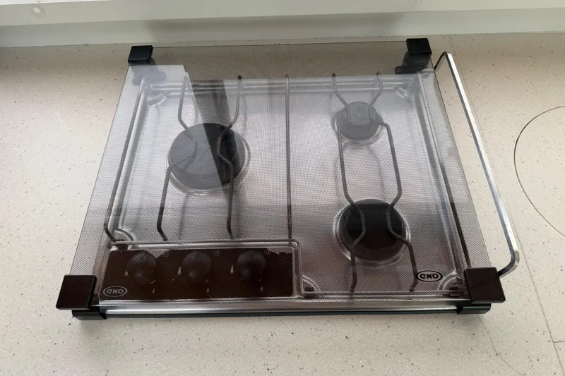 Slide: The Image of Three-burner gas stove with protective cover on a Nautitech 47, 2009 model. - 93