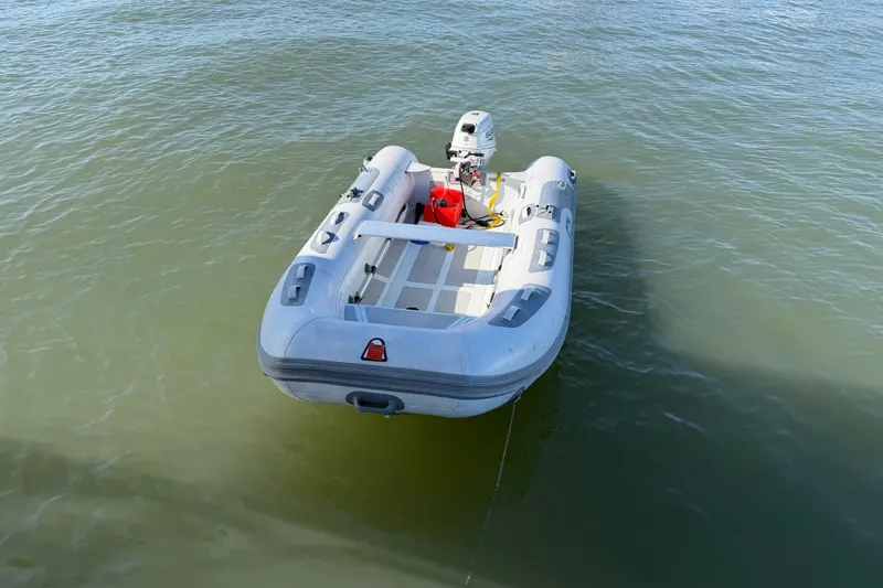 Slide: The Image of Inflatable dinghy on water, featuring an outboard motor, associated with Nautitech 47, 2009 model. - 97