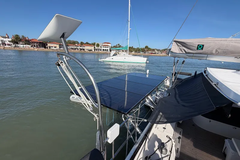 Slide: The Image of Nautitech 47 catamaran with solar panels docked near a scenic waterfront, 2009 model. - 98