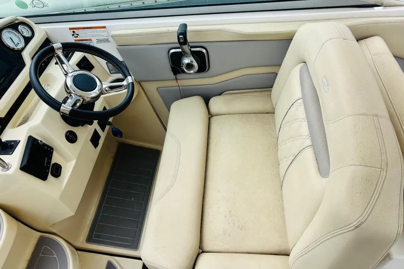 Slide: The Image of 2019 Regal 28 Express boat cockpit with steering wheel and beige seating. - 11
