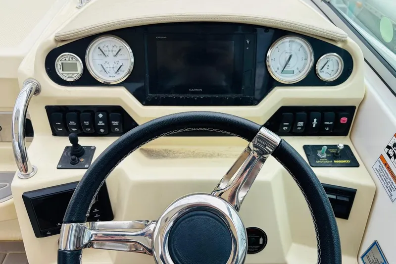 Slide: The Image of Steering console of a 2019 Regal 28 Express boat with gauges and controls. - 13