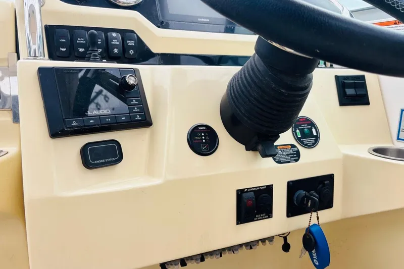 Slide: The Image of Control panel of a 2019 Regal 28 Express boat with steering wheel and audio system. - 16