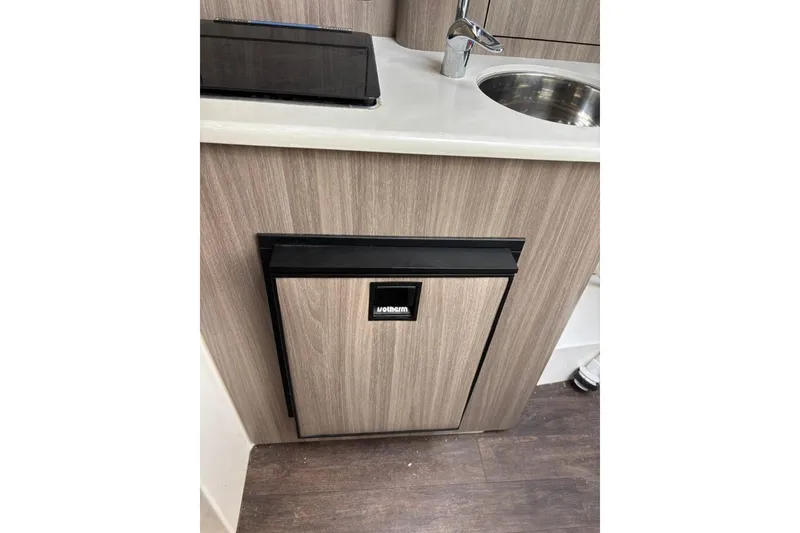 Slide: The Image of Compact kitchenette in 2019 Regal 28 Express boat with sink and mini fridge. - 22