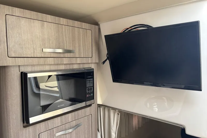 Slide: The Image of 2019 Regal 28 Express interior with microwave and mounted TV. - 23