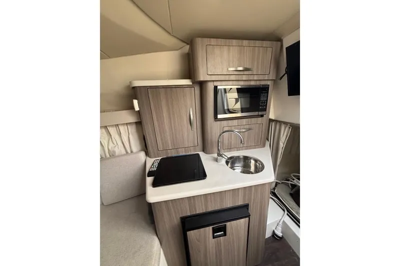 Slide: The Image of Compact kitchen area in 2019 Regal 28 Express boat with microwave and sink. - 25