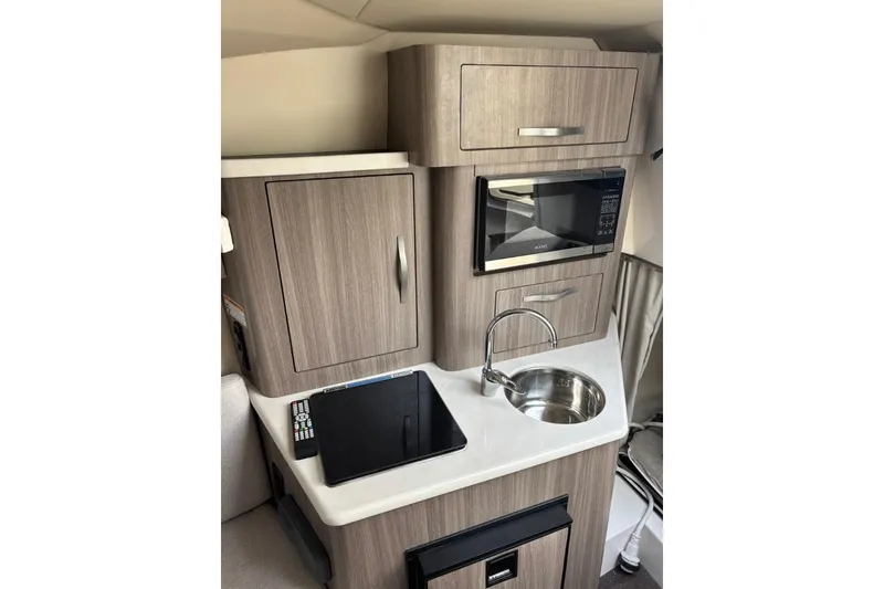 Slide: The Image of Compact kitchen area in 2019 Regal 28 Express boat with microwave and sink. - 26