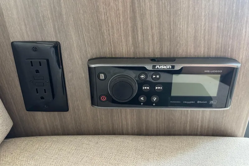 Slide: The Image of Power outlet and Fusion MS-UD650 stereo on 2019 Regal 28 Express boat interior. - 27
