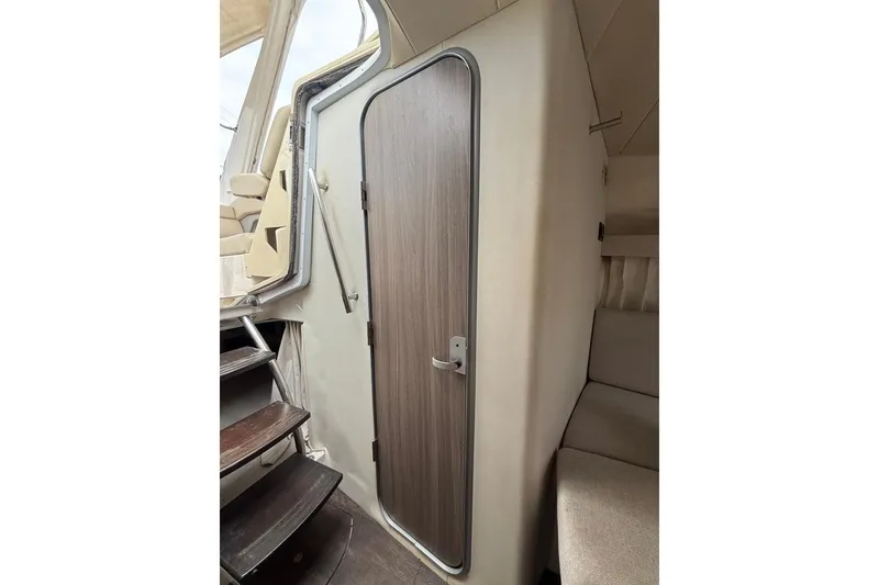 Slide: The Image of Interior cabin door of 2019 Regal 28 Express boat with adjacent seating and stairs. - 30