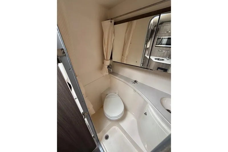 Slide: The Image of Compact bathroom in 2019 Regal 28 Express boat with toilet and mirror. - 31