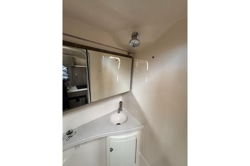Slide: The Image of 2019 Regal 28 Express boat bathroom with sink, mirror, and showerhead. - 32