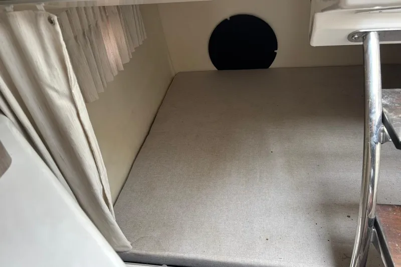 Slide: The Image of 2019 Regal 28 Express cabin interior with beige bedding and curtain. - 34