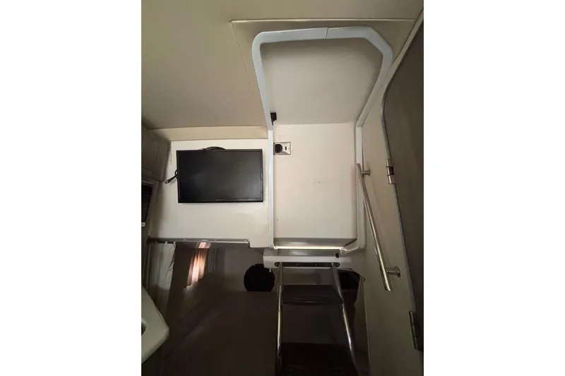 Slide: The Image of Interior of 2019 Regal 28 Express boat with TV and stairs. - 37