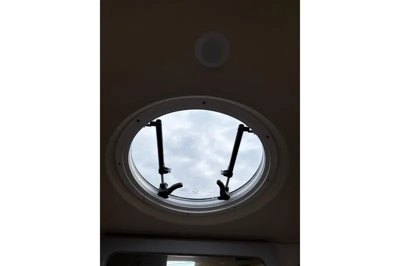 Slide: The Image of Circular hatch window on 2019 Regal 28 Express boat, showcasing sky view. - 38