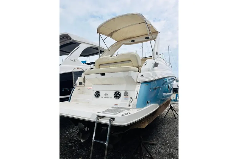 Slide: The Image of 2019 Regal 28 Express boat with blue hull and beige canopy, docked on land. - 41