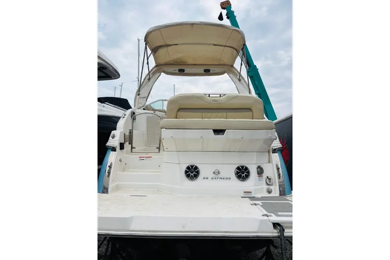 Slide: The Image of 2019 Regal 28 Express boat with canopy, rear view, docked under cloudy sky. - 45