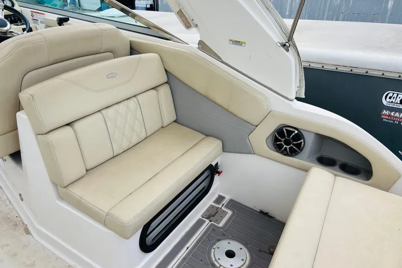 Slide: The Image of 2019 Regal 28 Express boat interior with beige seating and built-in speaker. - 7