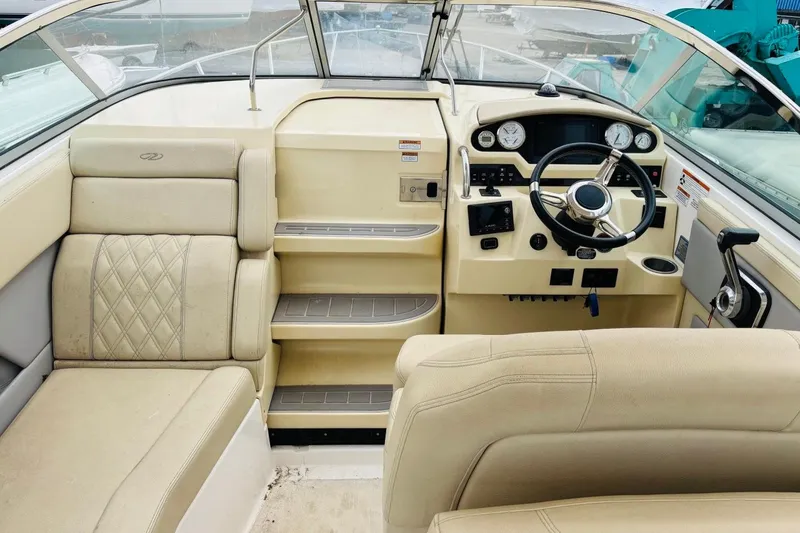 Slide: The Image of Interior view of a 2019 Regal 28 Express boat cockpit with beige seating and controls. - 9
