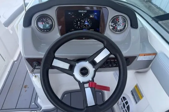 Slide: The Image of 2023 Chaparral 21 SSi boat dashboard with steering wheel and digital display. - 15