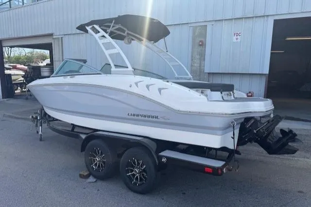 Slide: The Image of 2023 Chaparral 21 SSi boat on trailer, parked outside a building. - 3