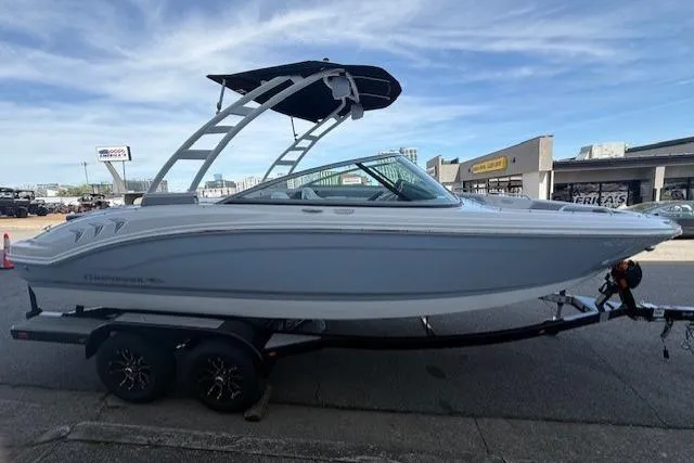 Slide: The Image of 2023 Chaparral 21 SSi boat on trailer, parked outdoors with buildings in background. - 5