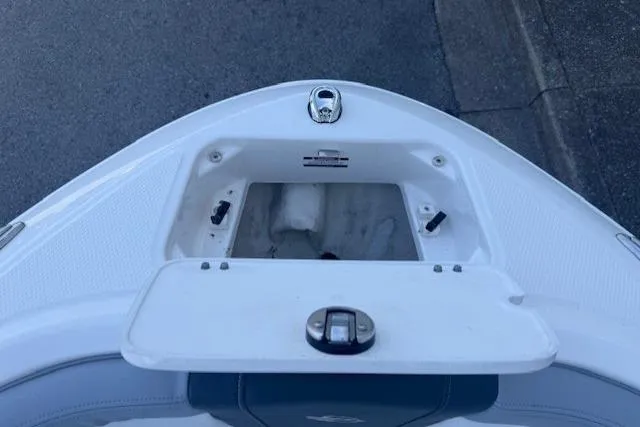 Slide: The Image of 2023 Chaparral 21 SSi boat bow storage compartment, open lid, white interior. - 7