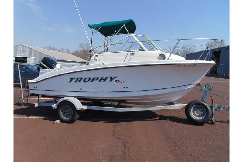 Slide: The Image of 2009 Trophy 1902 Walkaround boat on trailer, parked outdoors under clear sky. - 4
