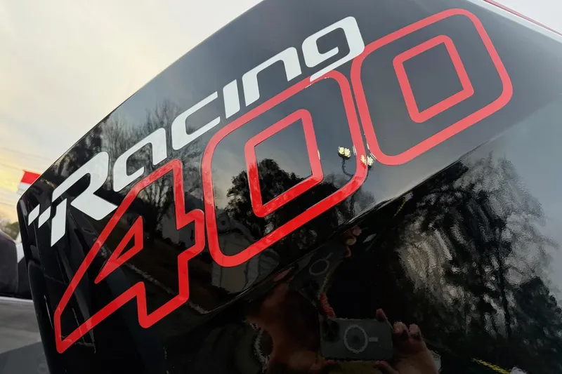 Slide: The Image of "Racing 400" decal on a sleek black surface, reflecting trees and sky. - 10