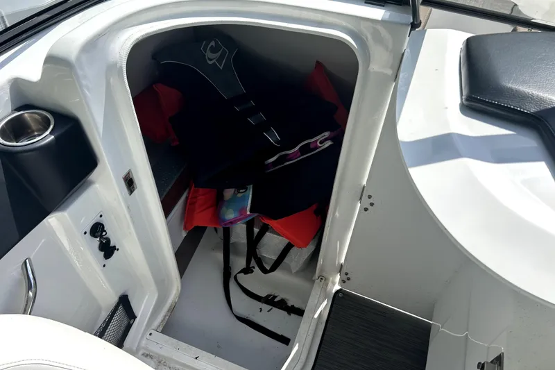 Slide: The Image of Storage compartment in a 2020 Scarab 255 ID boat with life jackets and accessories. - 29