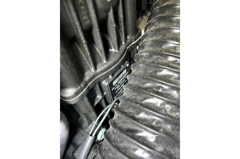 Slide: The Image of Close-up of a 2020 Scarab 255 ID engine component with visible wiring and textured surfaces. - 36