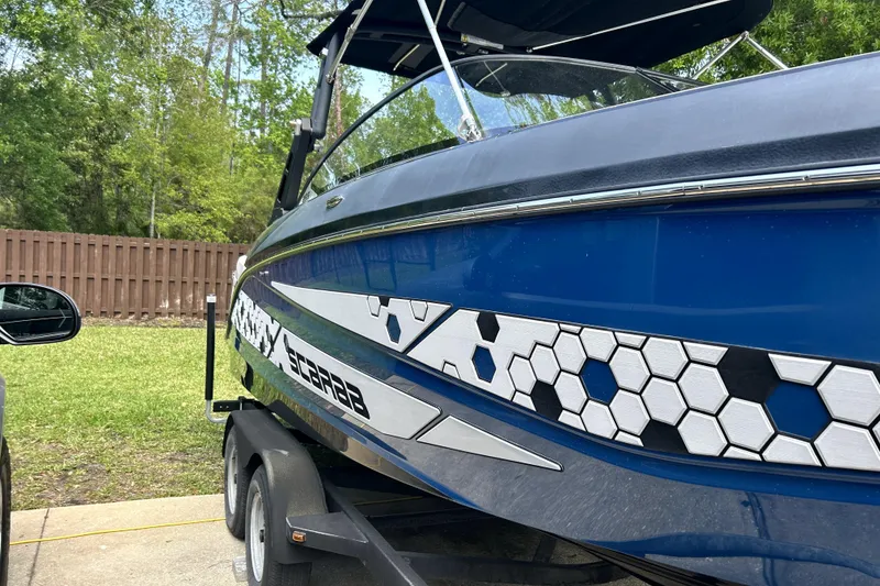 Slide: The Image of Blue 2020 Scarab 255 ID boat with hexagonal design on trailer. - 4