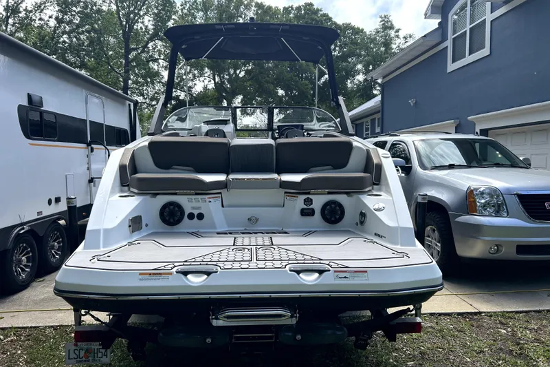 Slide: The Image of 2020 Scarab 255 ID boat parked beside a trailer and SUV in a driveway. - 5