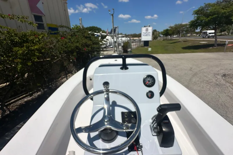 Slide: The Image of 2026 Delta D18 boat dashboard with steering wheel and controls, sunny day at marina. - 5
