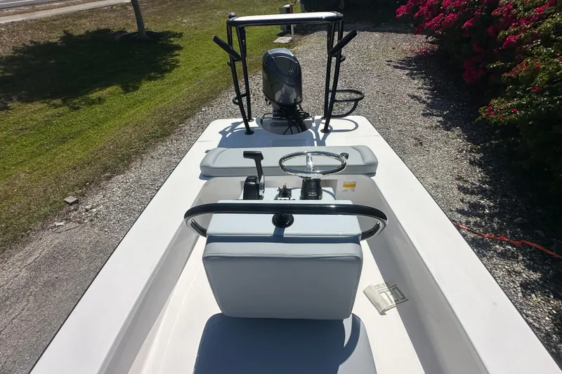 Slide: The Image of 2026 Delta Boatworks Delta D18 with steering console and outboard motor, parked on gravel. - 8