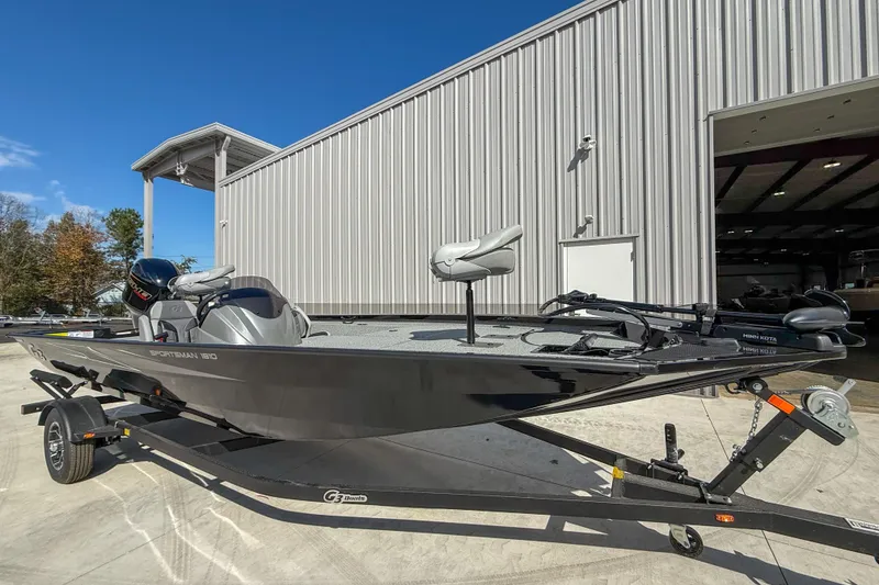 Slide: The Image of 2026 G3 Sportsman 1810 boat on trailer, parked outside a large metal building. - 3
