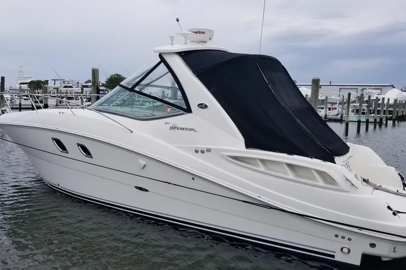 Slide: The Image of 2007 Sea Ray Sundancer 310 yacht docked at marina, featuring sleek design and black canopy. - 7