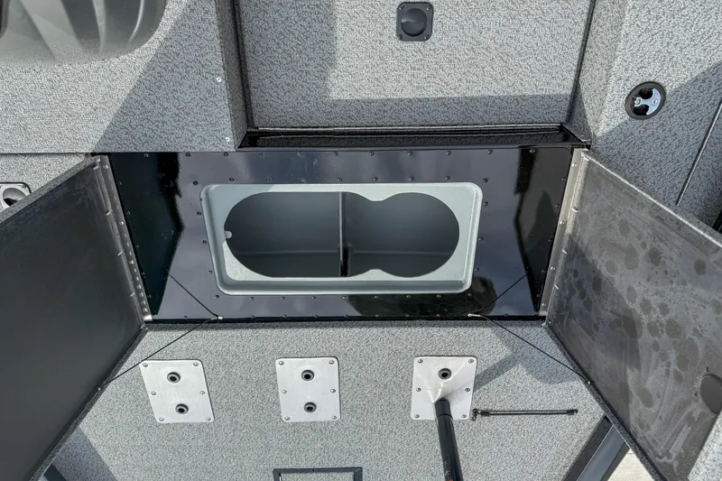 Slide: The Image of 2026 G3 Sportsman 1710 boat storage compartment with open hatches and textured surface. - 11
