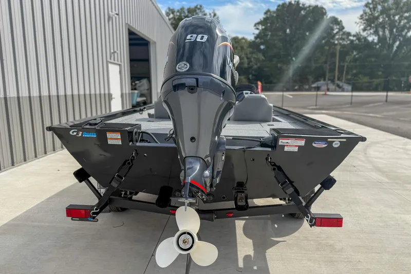 Slide: The Image of 2026 G3 Sportsman 1710 boat with outboard motor, parked outside a building. - 4