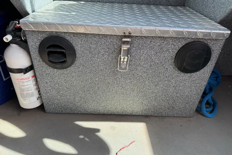 Slide: The Image of Storage compartment on a 2006 Alumaweld Stryker Sport 19 boat with fire extinguisher. - 16