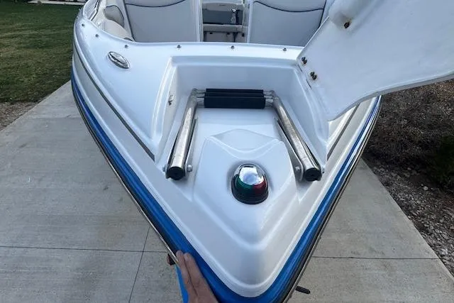 Slide: The Image of 2013 Rinker 246 Captiva Bowrider boat with open bow compartment on a concrete surface. - 11