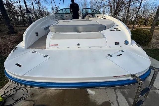 Slide: The Image of 2013 Rinker 246 Captiva Bowrider boat with spacious deck and seating, parked outdoors. - 12