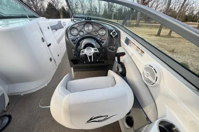 Slide: The Image of 2013 Rinker 246 Captiva Bowrider cockpit with steering wheel and dashboard controls. - 23