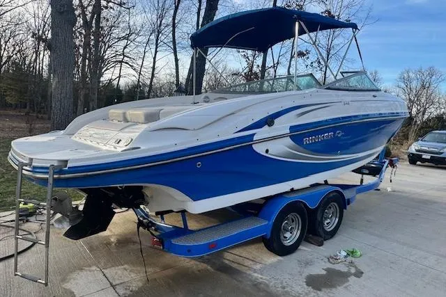 Slide: The Image of 2013 Rinker 246 Captiva Bowrider on trailer, blue and white design, parked outdoors. - 7