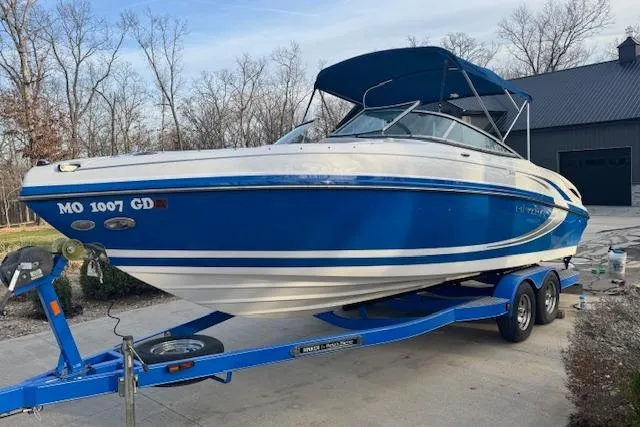Slide: The Image of 2013 Rinker 246 Captiva Bowrider on trailer, blue and white, parked outdoors. - 8