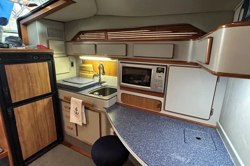 Slide: The Image of Interior of 1991 Sea Ray 400 Express Cruiser kitchen with sink, microwave, and cabinets. - 10