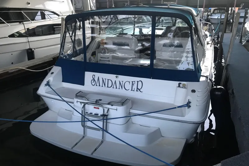 Slide: The Image of 1991 Sea Ray 400 Express Cruiser docked, rear view with "Sandancer" name visible. - 3