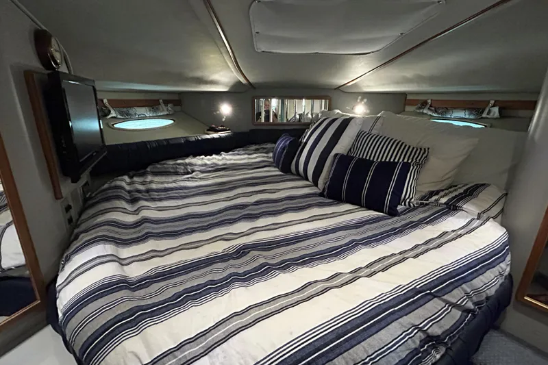 Slide: The Image of Cozy cabin interior of 1991 Sea Ray 400 Express Cruiser with striped bedding. - 4