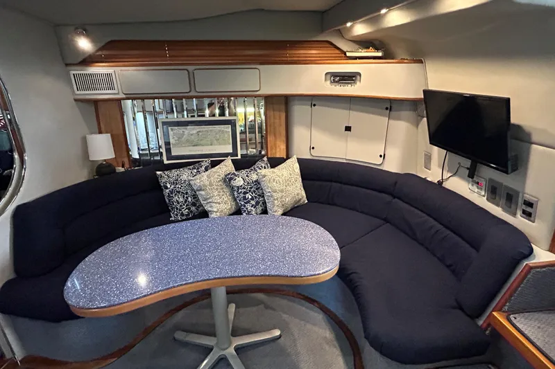 Slide: The Image of Interior of 1991 Sea Ray 400 Express Cruiser with curved seating and table. - 8
