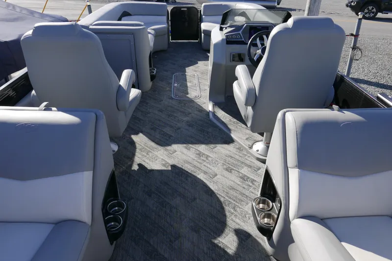 Slide: The Image of 2019 Manitou 25 Encore RF boat interior with gray seating and steering console. - 13