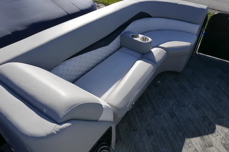 Slide: The Image of 2019 Manitou 25 Encore RF boat interior with gray seating and cup holders. - 6