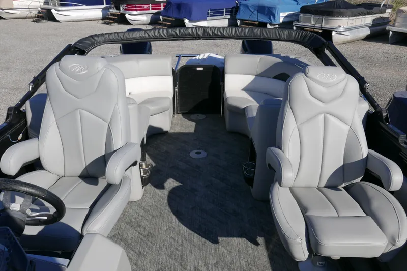 Slide: The Image of 2019 Manitou 25 Encore RF boat interior with gray seating and steering wheel. - 8
